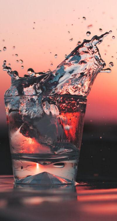 Kalkfreies Trinkwasser im Glas vor Sonnenuntergang